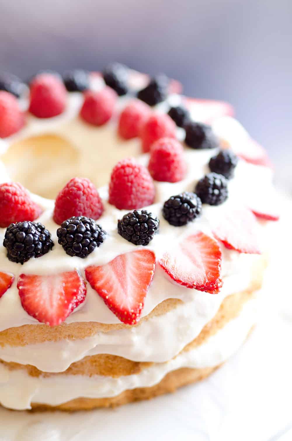 Light Berry Angel Food Cake is an easy and delicious 15 minute dessert. Angel food cake is layered with luscious white chocolate Cool Whip and topped with fresh berries for a guilt-free treat!