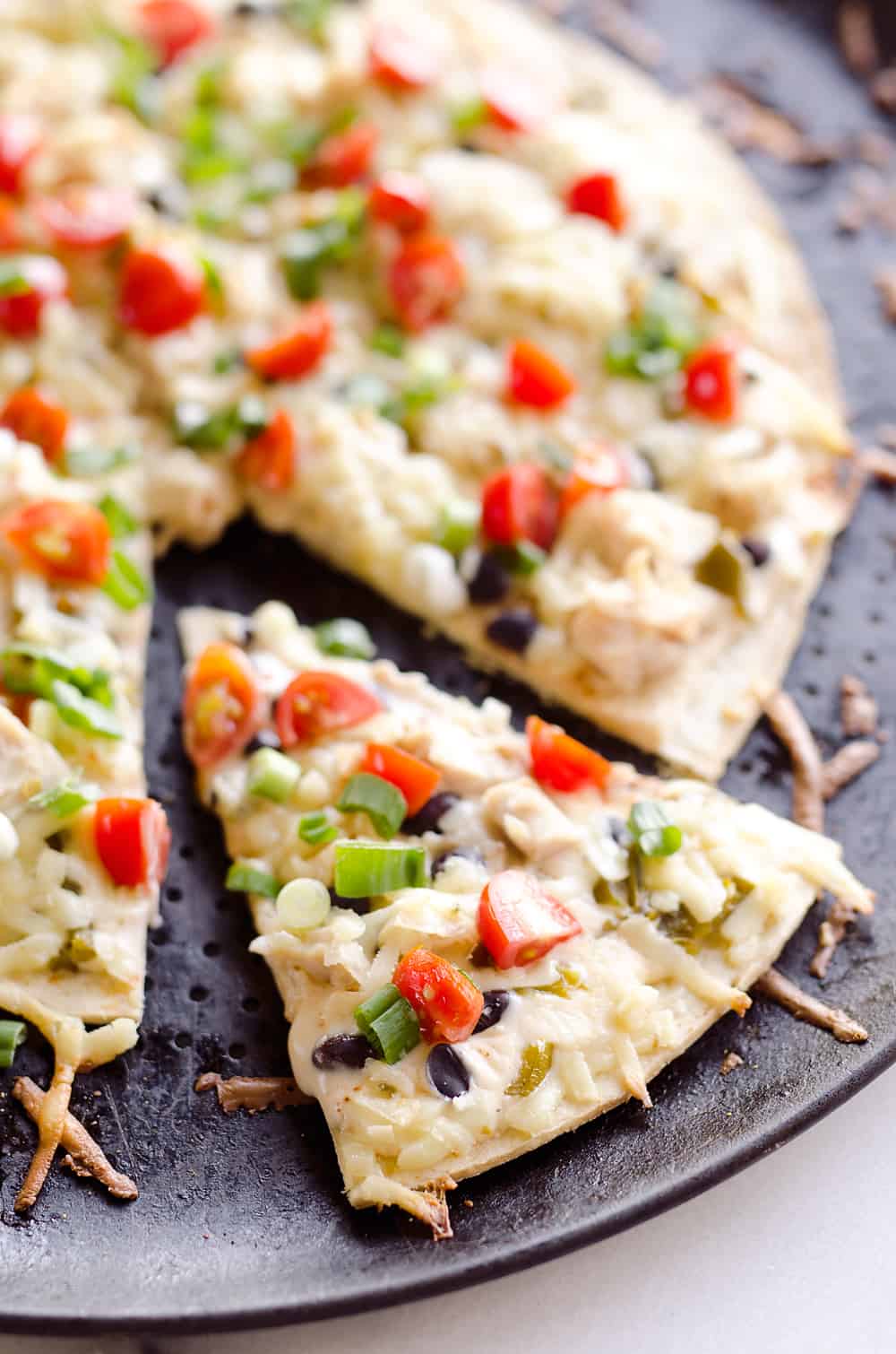 Light & Spicy Southwest Chicken Pizza is an easy recipe bursting with bold and spicy flavors. A thin and crispy crust is topped with shredded chicken, black beans and jalapeÒos and finished off with pepper jack cheese, fresh tomatoes and green onions for a delicious weeknight dinner idea.