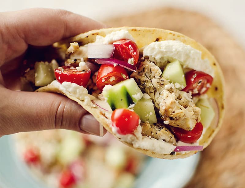 Greek Chicken Tacos with Whipped Feta held in hand