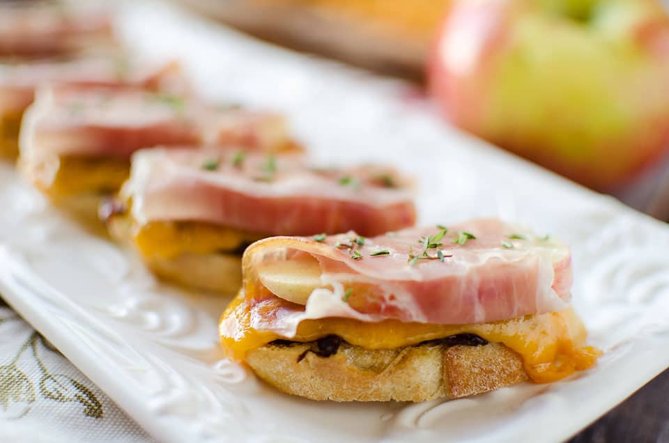 Caramelized Onion & Cheddar Crostinis with Prosciutto Wrapped Apples - Krafted Koch - A sophisticated appetizer made with smooth Boar's Head Sharp Cheddar Cheese, a recipe perfect for the holidays!