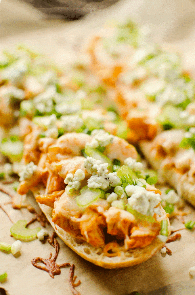 French bread topped with buffalo chicken, cheese, celery and gorgonzola on parchment