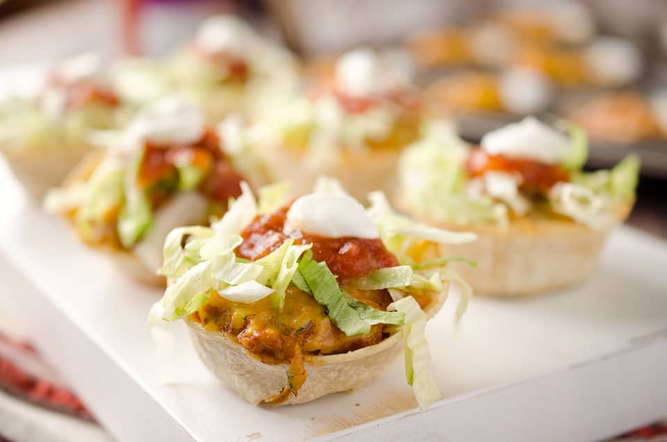 Light Mini Turkey Taco Cups - Krafted Koch - Tortilla cups filled with taco seasoned turkey and topped with lettuce, salsa and sour cream for the perfect healthy appetizer recipe! #Healthy #Appetizer #Light #Lunch