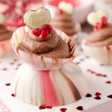 Pomegranate Chocolate Mousse Bowls are the perfect little cups of dessert with pomegranate and dark chocolate mousse filling up these adorable bowls made from swirled Ghirardelli melting wafers and topped with pomegranate seeds and chocolate hearts for a festive and colorful Valentine's recipe that will impress your loved one this Valentine's Day! #Valentines #Ghirardelli #Chocolate #Dessert