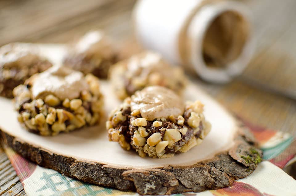 Peanut Butter & Chocolate Thumbprint Cookies - Krafted Koch - A rich chocolate cookie recipe rolled in walnuts and filled with sweet peanut butter frosting for the perfect cookie! #Cookie #Recipe #PeanutButter #Chocolate