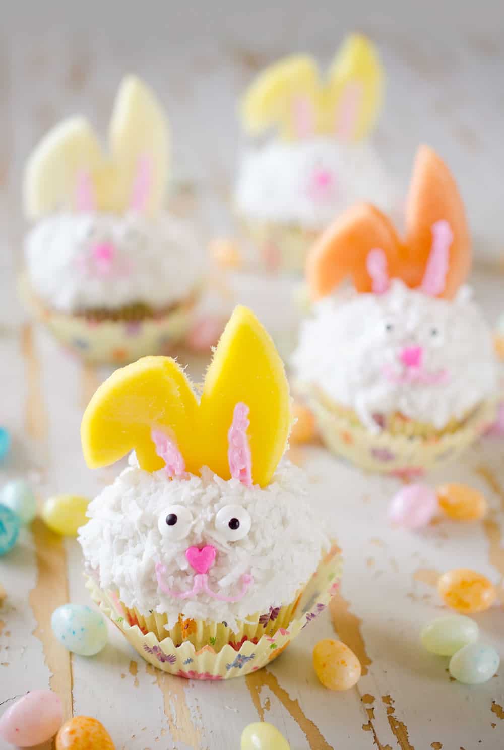 Light Coconut Cream Easter Bunny Cupcakes are a fun and healthy spring dessert recipe. Lightened up cupcakes are topped with bunny ears made from fruit, for a holiday treat kids and adults will LOVE! #Easter #Cupcakes #Light #Healthy