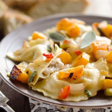 Roasted Squash & Sausage Ravioli is easy weeknight comfort food with roasted butternut squash, onions and bell peppers tossed with sausage ravioli and a butter sage sauce. #Squash #Sausage #Pasta #ComfortFood #Ravioli