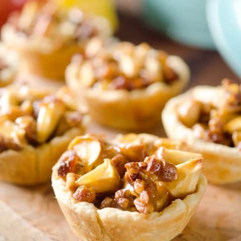 Caramel Apple Mini Pie Cups are a sweet little bite of apple pie loaded with walnuts, raisins and drizzled with caramel for the perfect party appetizer or snack!