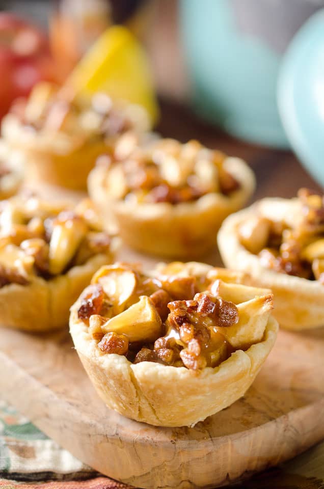 Caramel Apple Mini Pie Cups are a sweet little bite of apple pie loaded with walnuts, raisins and drizzled with caramel for the perfect party appetizer or snack!