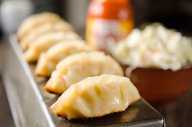 Buffalo Chicken Potstickers are a surprisingly easy and healthy dinner with chewy wrappers filled with lean ground chicken, vegetables and buffalo sauce.