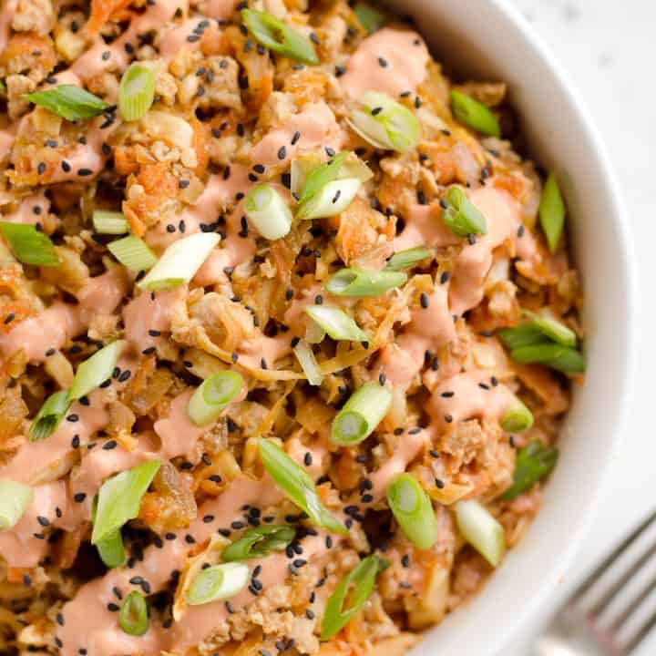 Turkey Egg Roll Bowl with Creamy Sriracha is an amazingly healthy and delicious bowl of goodness perfect for lunch or dinner! Sauteed cabbage, carrots, onion and ground turkey are tossed with an Asian inspired sauce and topped with a creamy Greek yogurt sriracha mayo sauce.