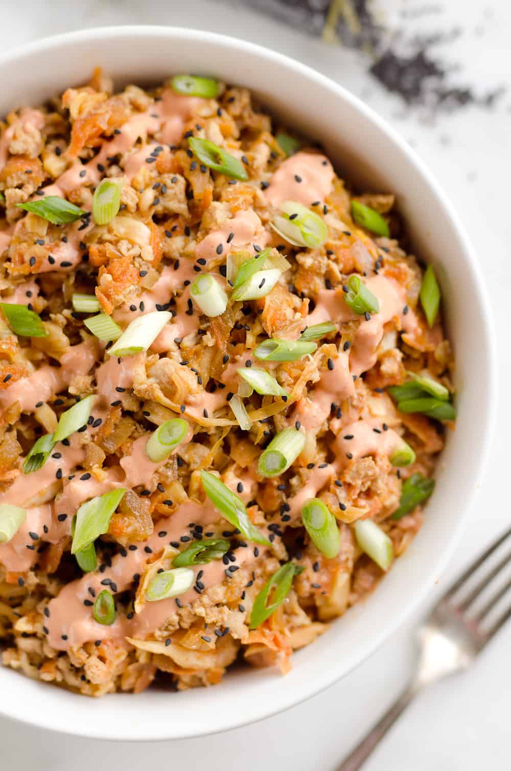 Turkey Egg Roll Bowl with Creamy Sriracha is an amazingly healthy and delicious bowl of goodness perfect for lunch or dinner! Sauteed cabbage, carrots, onion and ground turkey are tossed with an Asian inspired sauce and topped with a creamy Greek yogurt sriracha mayo sauce.