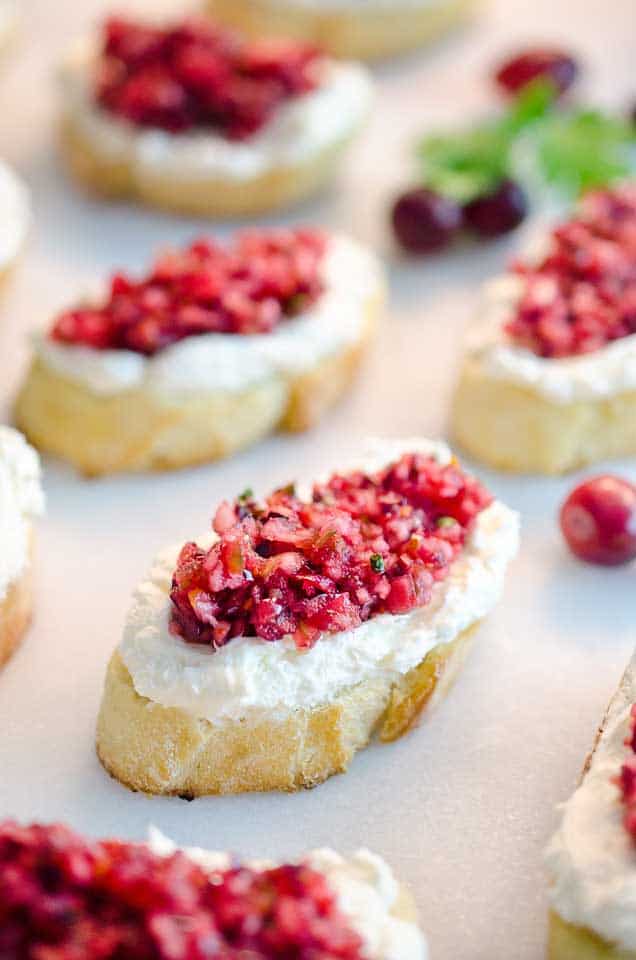 Cranberry Cream Cheese Bruschetta are a fresh twist on a classic appetizer. Toasted french bread is topped with cream cheese and a spicy cranberry salsa for an hors d'oeuvre perfect for any holiday party!