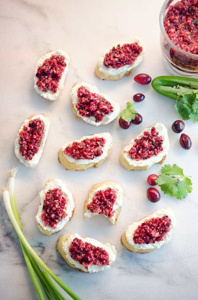 Cranberry Cream Cheese Bruschetta are a fresh twist on a classic appetizer. Toasted french bread is topped with cream cheese and a spicy cranberry salsa for an hors d'oeuvre perfect for any holiday party!