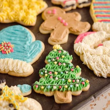 frosted sour cream cutout cookies on baking sheet