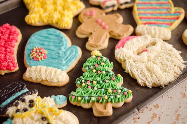 frosted sour cream cutout cookies on baking sheet