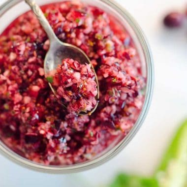 Spicy Cranberry Salsa is a fresh blend of cranberries, jalapeños, cilantro, honey and citrus for a healthy condiment perfect with turkey or spread on cream cheese and served with crackers for an easy appetizer!