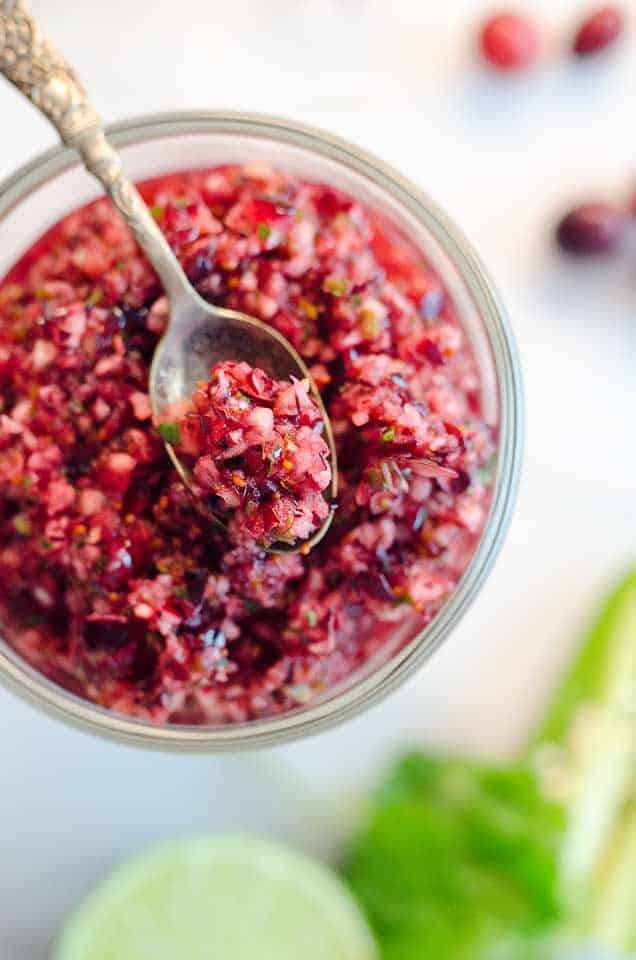 Spicy Cranberry Salsa is a fresh blend of cranberries, jalapeños, cilantro, honey and citrus for a healthy condiment perfect with turkey or spread on cream cheese and served with crackers for an easy appetizer!