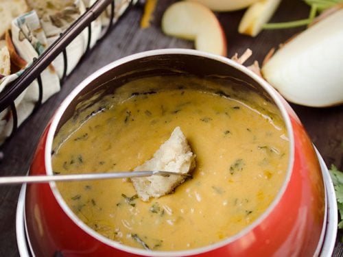 Zesty Cheddar Fondue is an easy and delicious appetizer perfect for the holidays. It is a creamy cheese fondue filled with rich sharp cheddar, onions, garlic and cilantro that pairs perfectly with bread and apples.