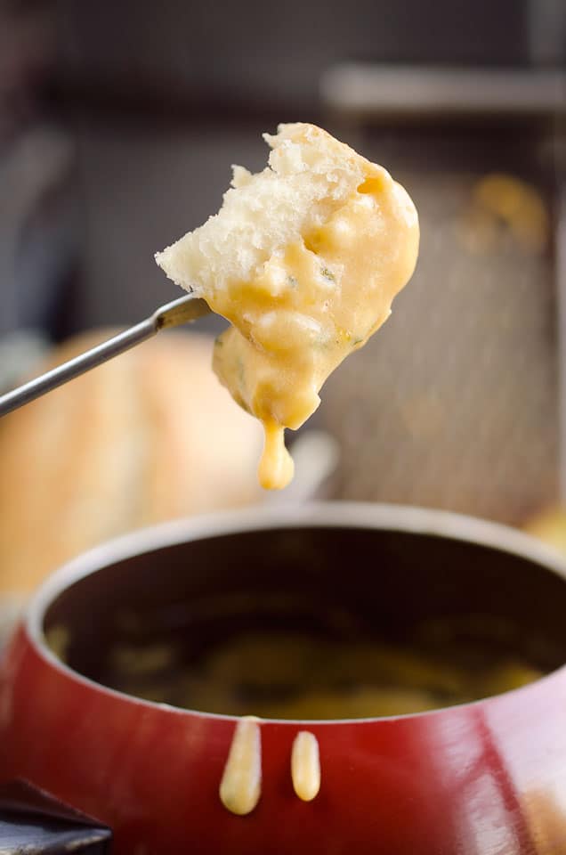 Zesty Cheddar Fondue is an easy and delicious appetizer perfect for the holidays. It is a creamy cheese fondue filled with rich sharp cheddar, onions, garlic and cilantro that pairs perfectly with bread and apples.