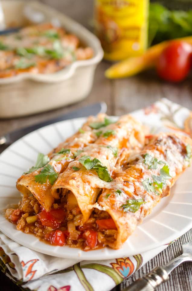 30 Minute Light Chicken Enchiladas are full of crumbled chicken & vegetables and a spicy enchilada sauce for an easy weeknight dinner!