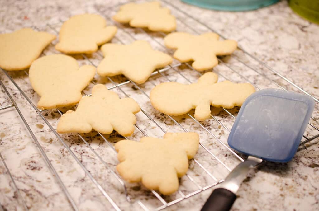 sour cream cut out cookies on cooking wrack with spatula turner