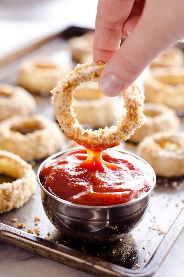 Baked Southwest Onion Rings are a lightened up version of a classic appetizer! Onions are coated in whole wheat flour, eggs, panko break crumbs and a mix of southwest spices and baked instead of fried for a healthy side dish.