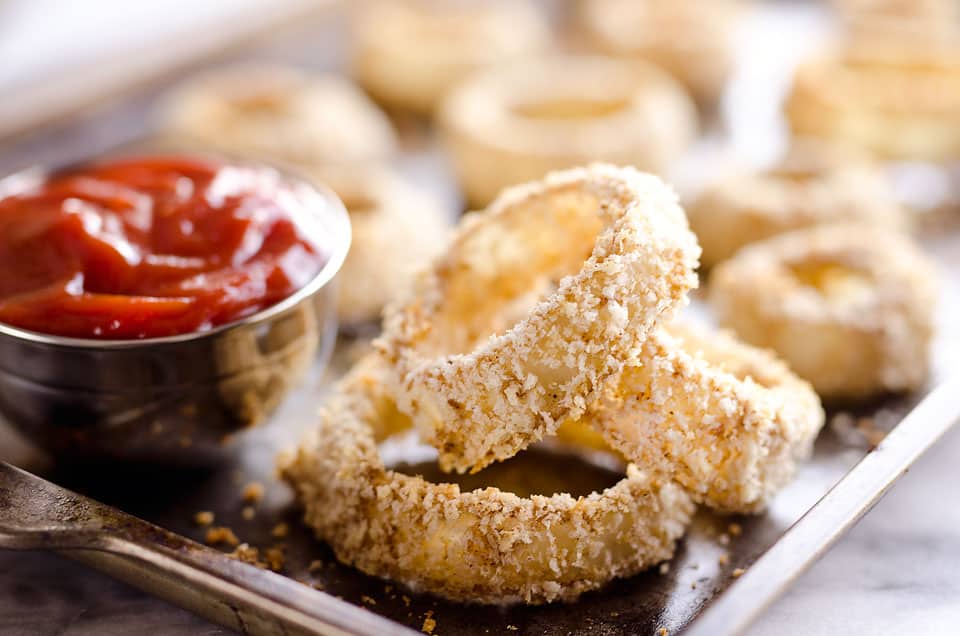 Baked Southwest Onion Rings are a lightened up version of a classic appetizer! Onions are coated in whole wheat flour, eggs, panko break crumbs and a mix of southwest spices and baked instead of fried for a healthy side dish. 