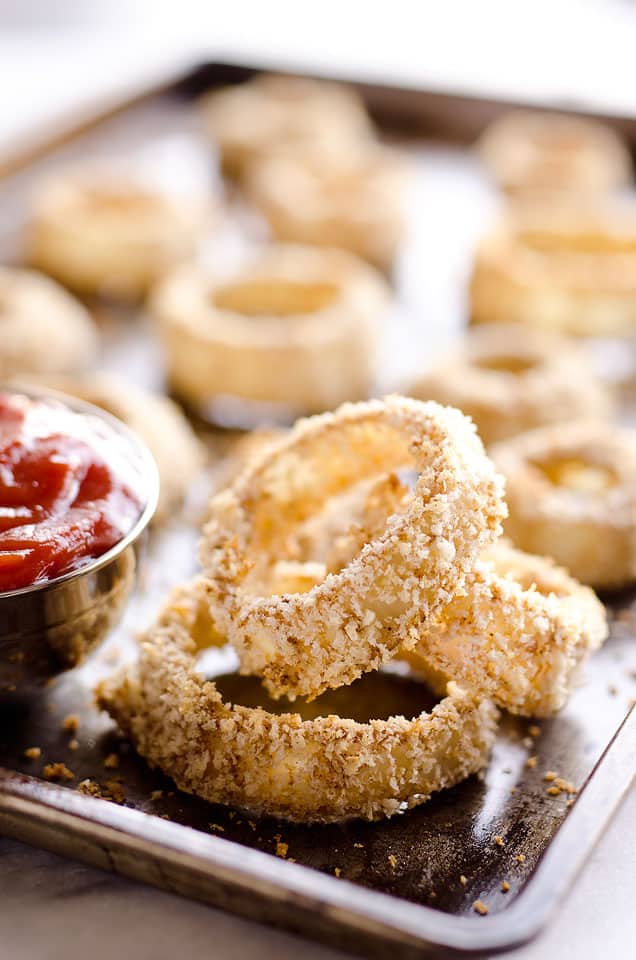 Baked Southwest Onion Rings are a lightened up version of a classic appetizer! Onions are coated in whole wheat flour, eggs, panko break crumbs and a mix of southwest spices and baked instead of fried for a healthy side dish.