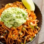 Spicy Roasted Sweet Potato Spirals with Guacamole is an amazingly delicious meatless dinner or appetizer with crispy sweet potatoes coated in garlic & chili powder and topped with a zesty guacamole.