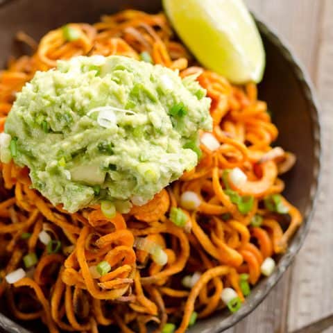 Spicy Roasted Sweet Potato Spirals with Guacamole is an amazingly delicious meatless dinner or appetizer with crispy sweet potatoes coated in garlic & chili powder and topped with a zesty guacamole.