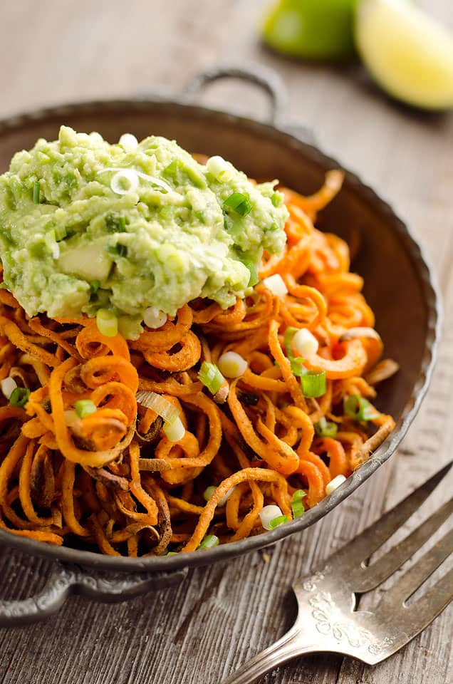 Spicy Roasted Sweet Potato Spirals with Guacamole is an amazingly delicious meatless dinner or appetizer with crispy sweet potatoes coated in garlic & chili powder and topped with a zesty guacamole.