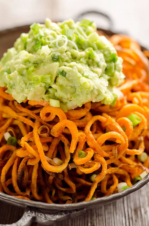 Spicy Roasted Sweet Potato Spirals with Guacamole is an amazingly delicious meatless dinner or appetizer with crispy sweet potatoes coated in garlic & chili powder and topped with a zesty guacamole. 