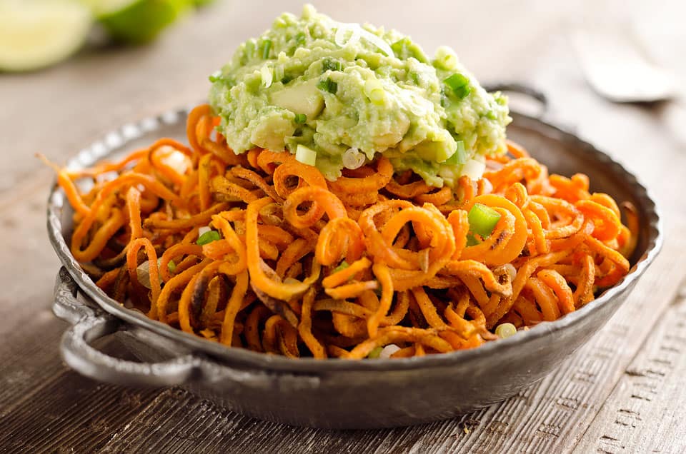 Spicy Roasted Sweet Potato Spirals with Guacamole is an amazingly delicious meatless dinner or appetizer with crispy sweet potatoes coated in garlic & chili powder and topped with a zesty guacamole. 