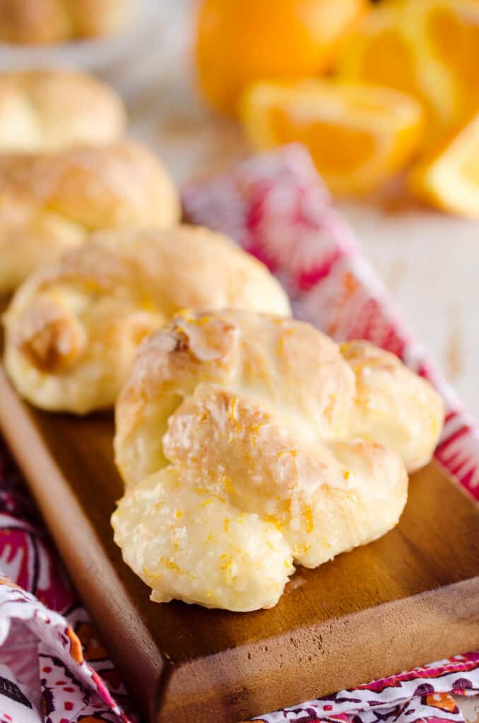 orange sweet roll knots on board with fresh oranges