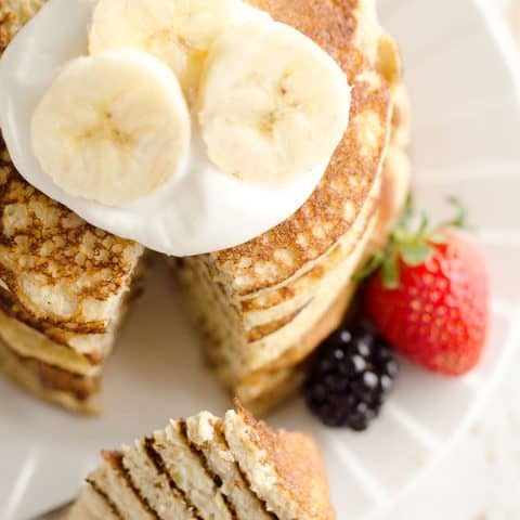 bite of protein banana pancakes on fork with stack