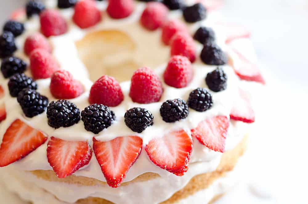 Light Berry Angel Food Cake is an easy and delicious 15 minute dessert. Angel food cake is layered with luscious white chocolate Cool Whip and topped with fresh berries for a guilt-free treat!