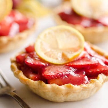 Mini Strawberry Lemon Pies are the perfect dessert recipe to serve your party guests for an individual sweet they will love! A flaky pie crust is topped with a lemon cream cheese layer, fresh strawberries and a sweet strawberry lemon sauce for tons of great flavor and texture!