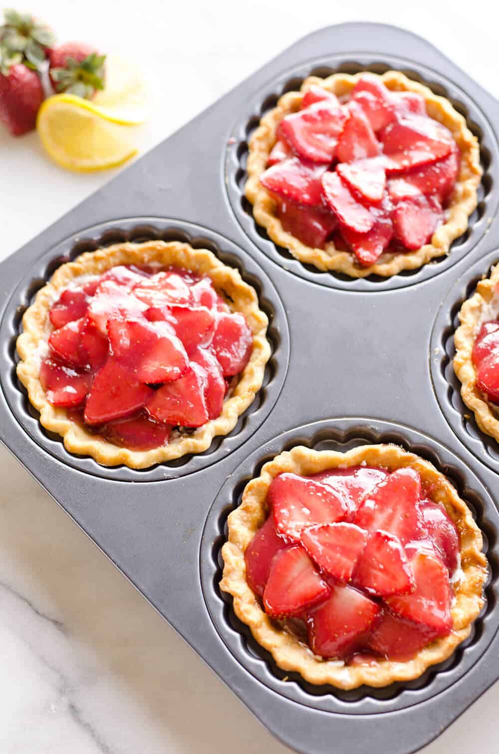 Mini Strawberry Lemon Pies are the perfect dessert recipe to serve your party guests for an individual sweet they will love! A flaky pie crust is topped with a lemon cream cheese layer, fresh strawberries and a sweet strawberry lemon sauce for tons of great flavor and texture!
