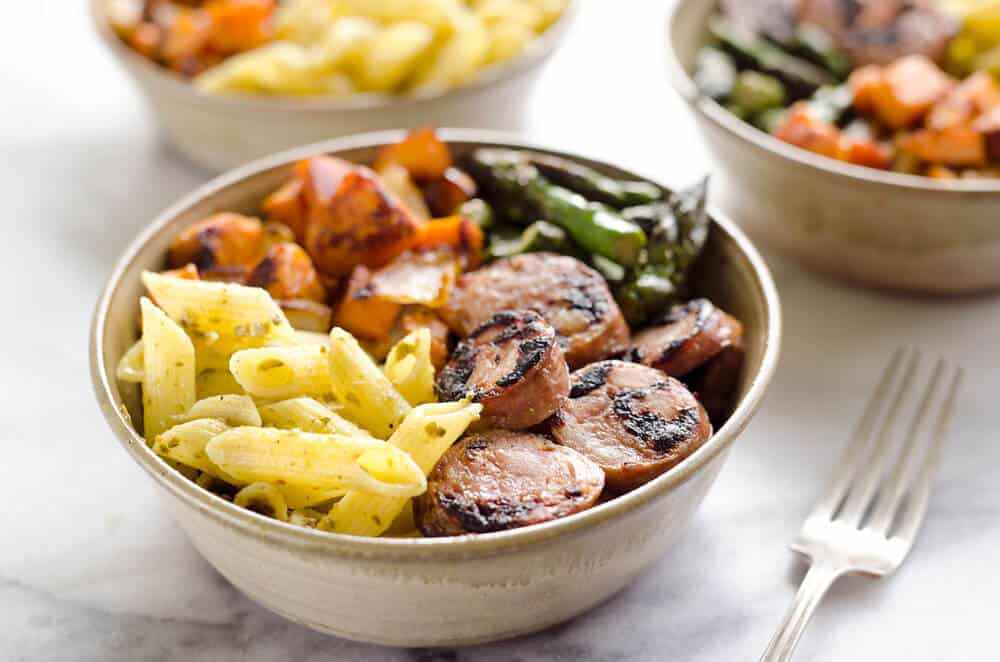 Roasted Veggie & Chicken Sausage Penne Bowls are a healthy gluten free dinner recipe bursting with bold flavors and wholesome ingredients. From chipotle roasted sweet potatoes and Aidells Chicken & Apple Sausage to Barilla Gluten Free Penne Pasta tossed in pesto, this dish is a well-rounded and satisfying meal you will love. 