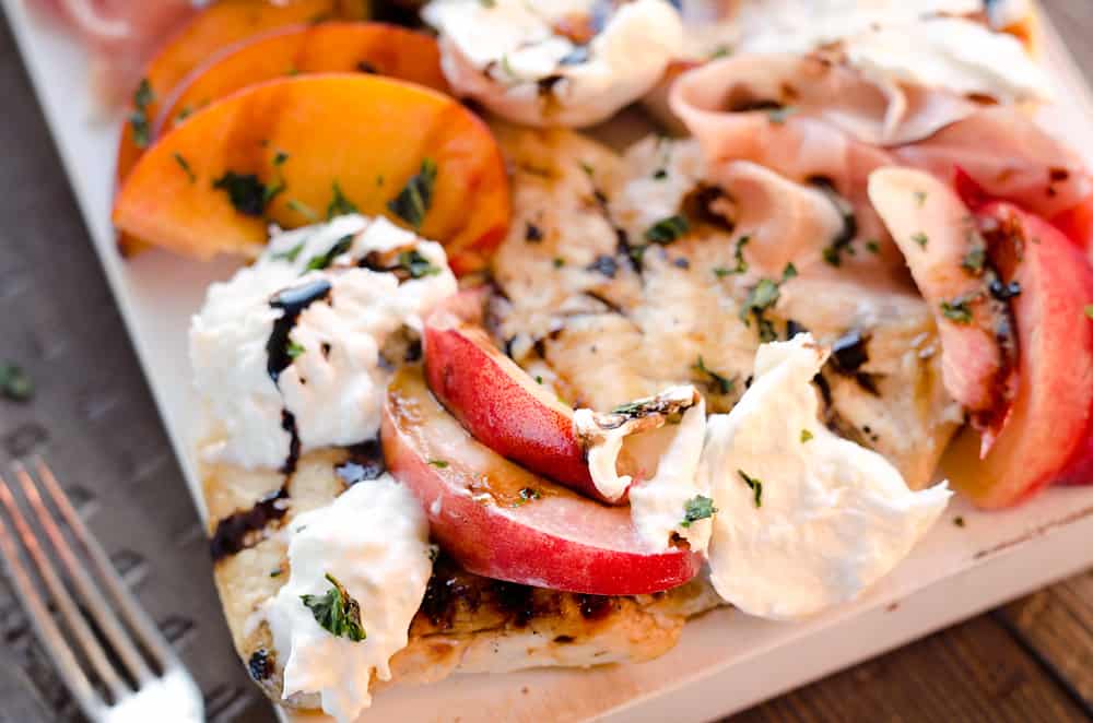 Balsamic Chicken with Peaches & Prosciutto is a deliciously simple and healthy dinner made on the grill in just 10 minutes! Grilled chicken is topped with fresh peaches and burrata cheese and finished off with a balsamic reduction and basil for a combination of flavors you will love. 
