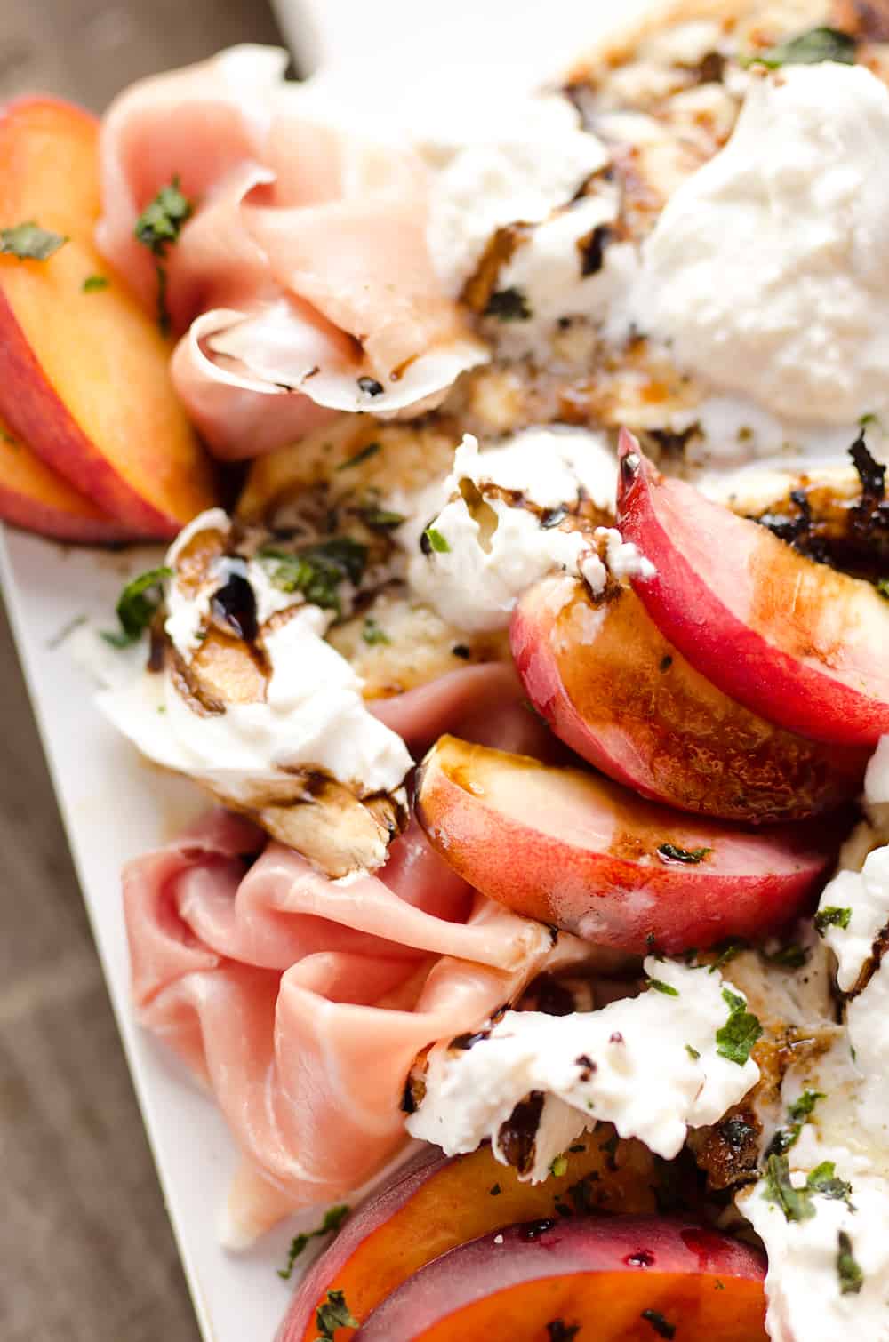 Balsamic Chicken with Peaches & Prosciutto is a deliciously simple and healthy dinner made on the grill in just 10 minutes! Grilled chicken is topped with fresh peaches and burrata cheese and finished off with a balsamic reduction and basil for a combination of flavors you will love.