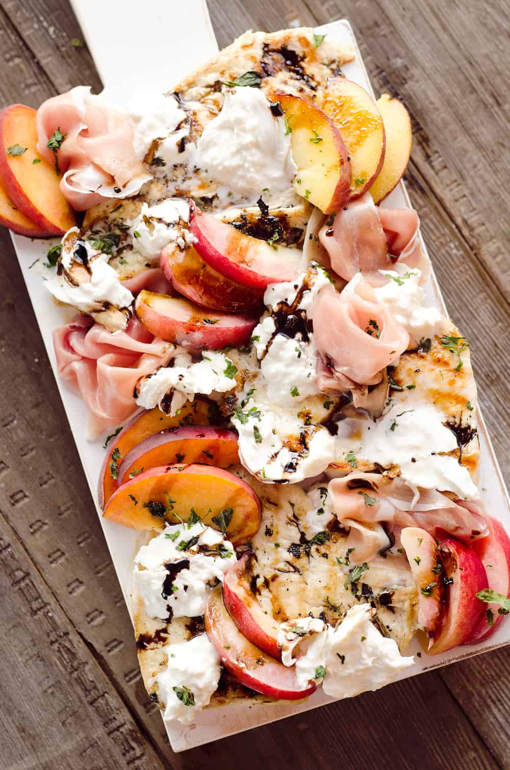 Balsamic Chicken with Peaches & Prosciutto is a deliciously simple and healthy dinner made on the grill in just 10 minutes! Grilled chicken is topped with fresh peaches and burrata cheese and finished off with a balsamic reduction and basil for a combination of flavors you will love. 