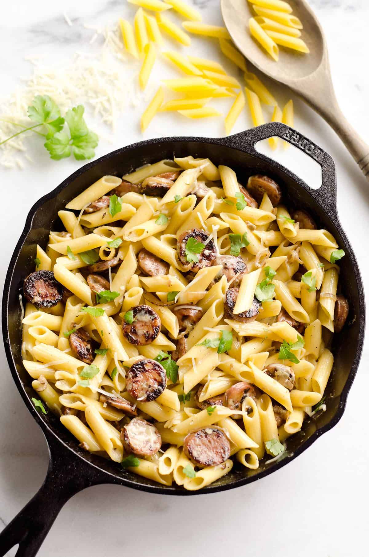 Chicken Sausage & Penne Skillet is an easy gluten free dinner idea loaded with rich flavors. Penne Pasta is tossed with a white wine and Parmesan cream sauce along with chicken apple sausage and shallots for a hearty dinner bursting with amazing flavor. 