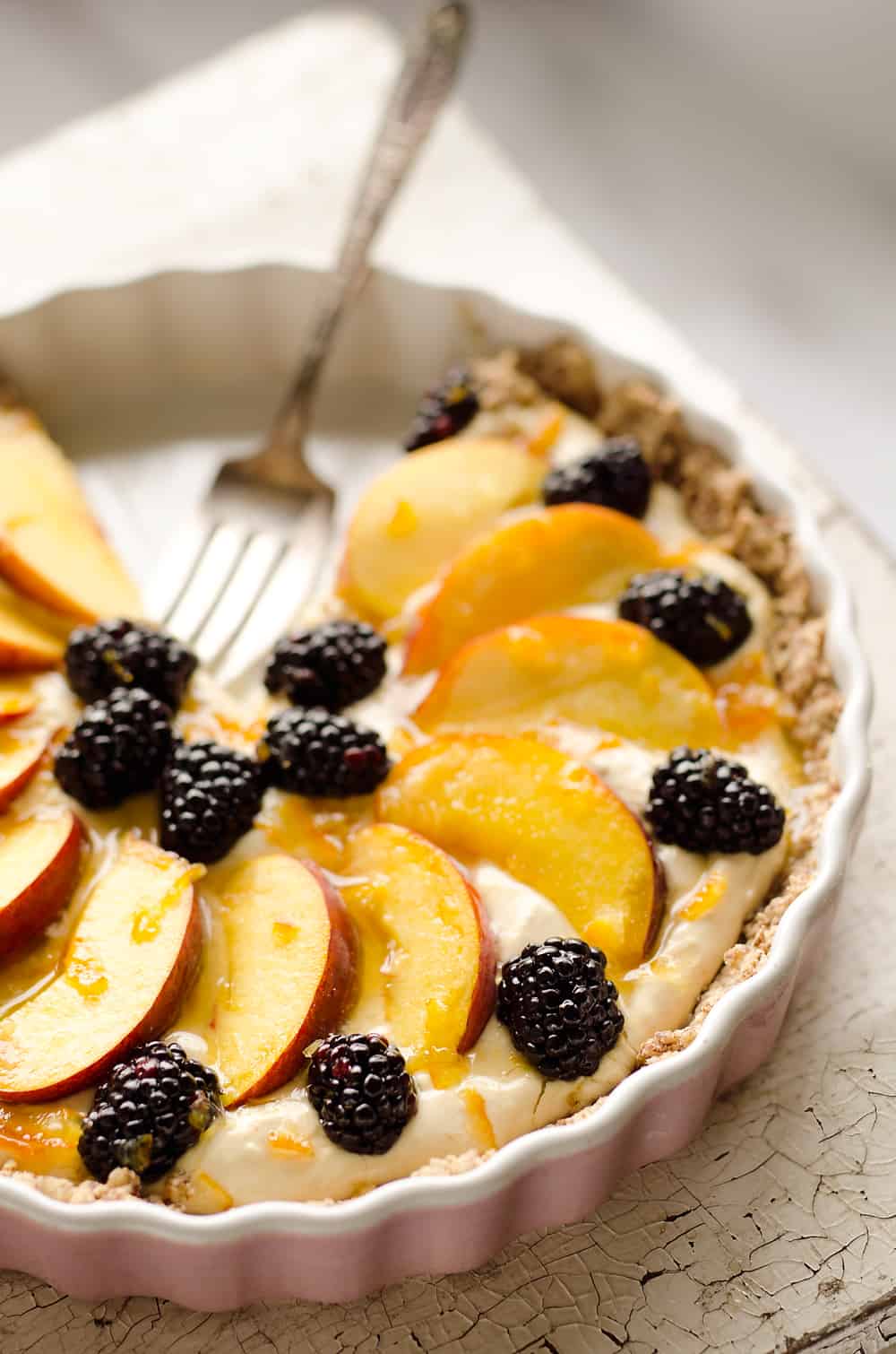 Light Peach & Berry Tart is a lightened up dessert loaded with an orange, cream cheese and Greek yogurt layer and topped with fresh peaches and berries for a spectacular sweet!