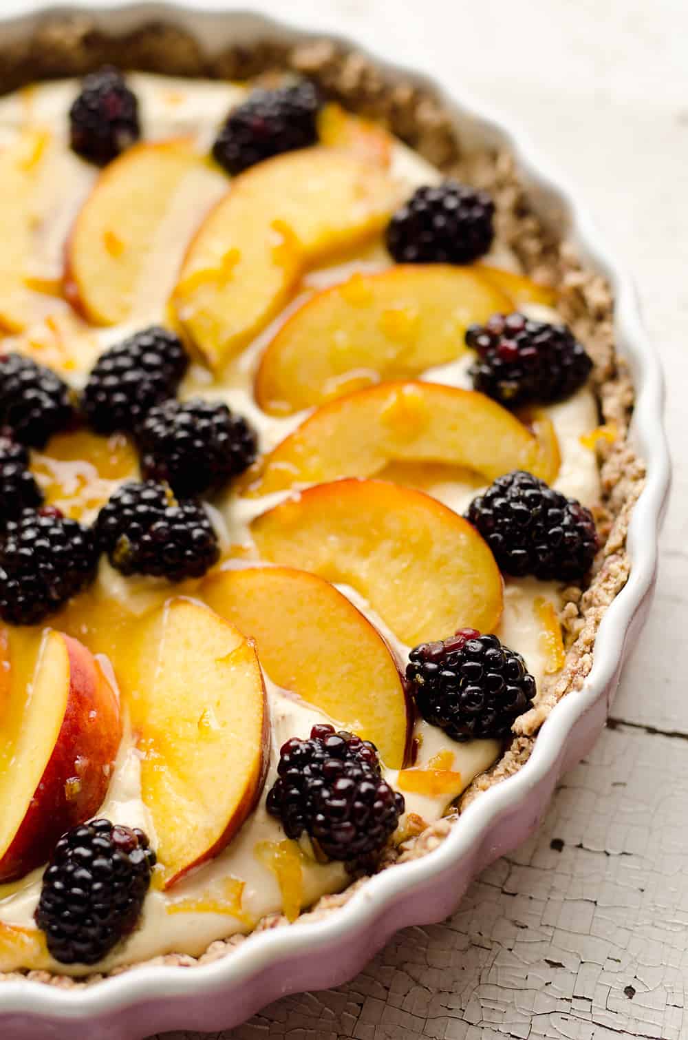 Light Peach & Berry Tart is a lightened up dessert loaded with an orange, cream cheese and Greek yogurt layer and topped with fresh peaches and berries for a spectacular sweet!