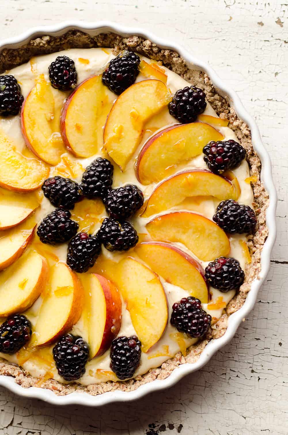 Light Peach & Berry Tart is a lightened up dessert loaded with an orange, cream cheese and Greek yogurt layer and topped with fresh peaches and berries for a spectacular sweet!