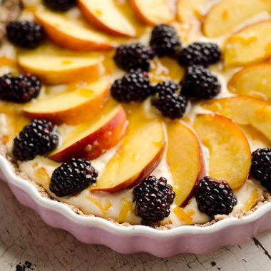 Light Peach & Berry Tart is a lightened up dessert loaded with an orange, cream cheese and Greek yogurt layer and topped with fresh peaches and berries for a spectacular sweet!