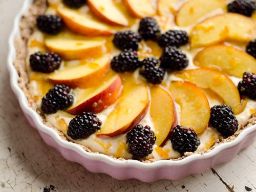 Light Peach & Berry Tart is a lightened up dessert loaded with an orange, cream cheese and Greek yogurt layer and topped with fresh peaches and berries for a spectacular sweet!