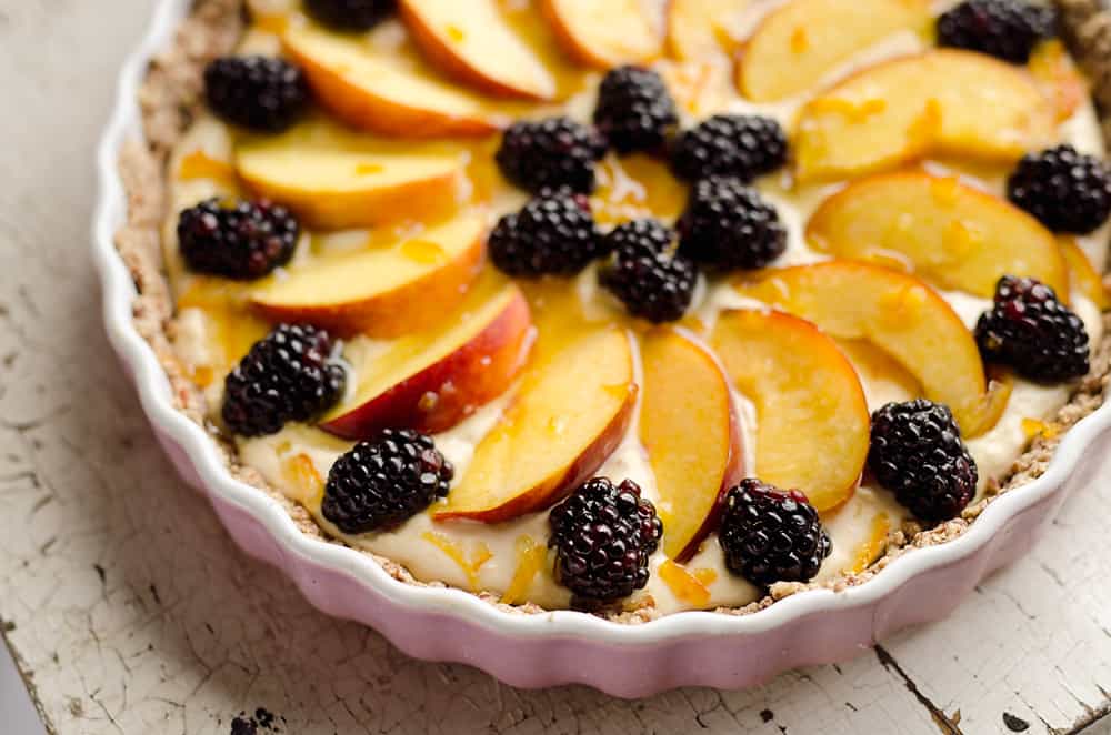 Light Peach & Berry Tart is a lightened up dessert loaded with an orange, cream cheese and Greek yogurt layer and topped with fresh peaches and berries for a spectacular sweet!