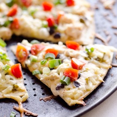 Light & Spicy Southwest Chicken Pizza is an easy recipe bursting with bold and spicy flavors. A thin and crispy crust is topped with shredded chicken, black beans and jalapeños and finished off with pepper jack cheese, fresh tomatoes and green onions for a delicious weeknight dinner idea.